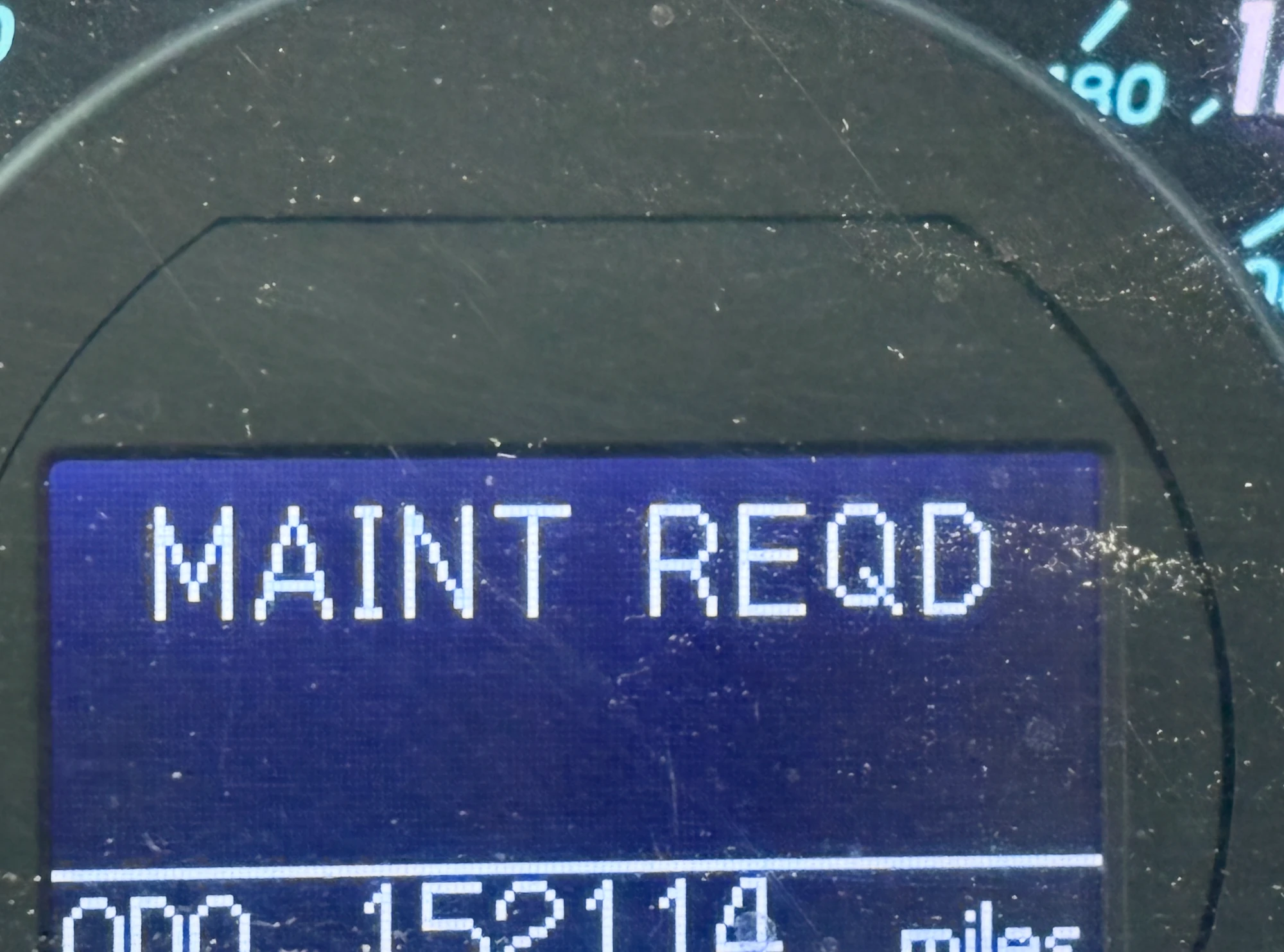 Car dashboard showing a maintenance required warning