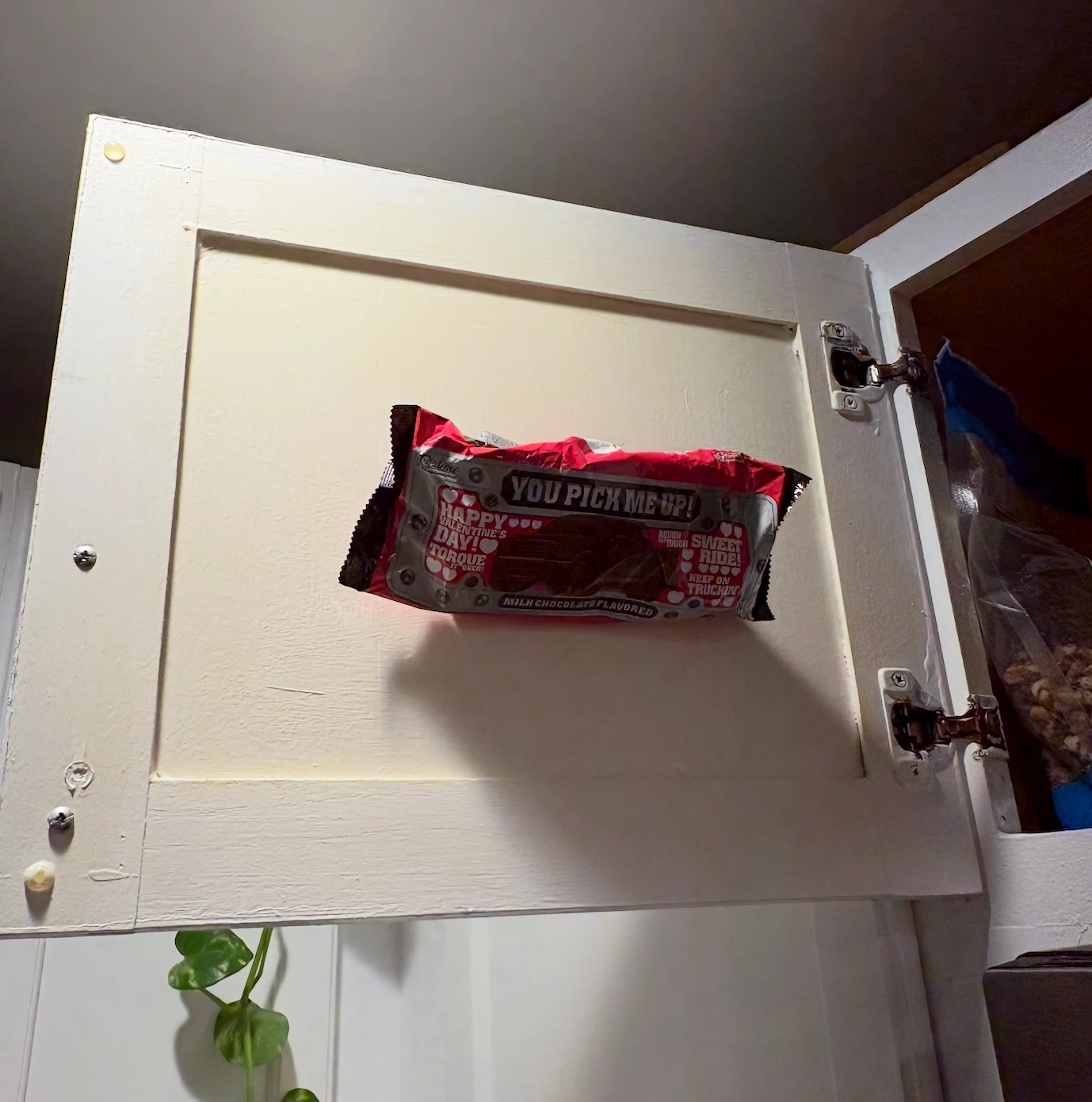 A chocolate candy bar hidden inside a kitchen cabinet